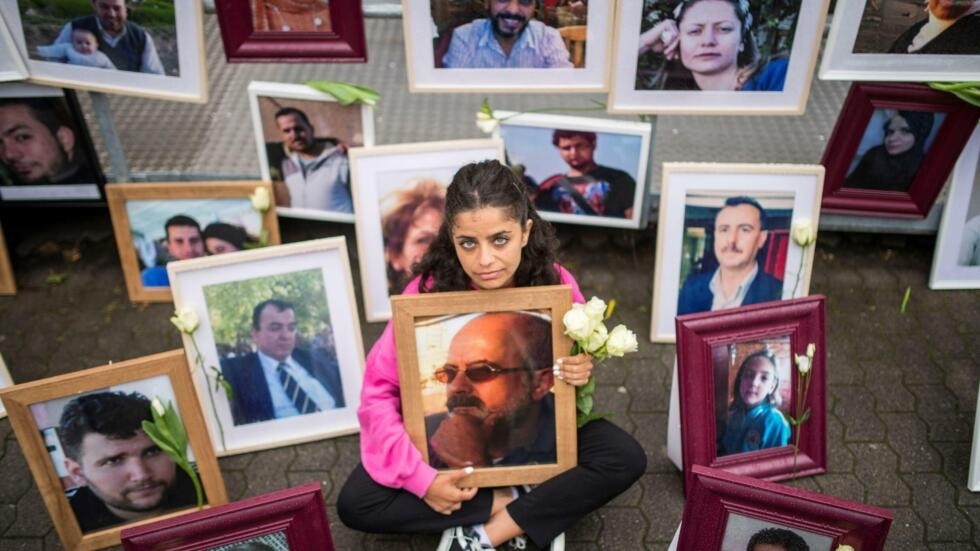 Syrian activist Wafa Mustafa holds a picture of her father, one of many victims of abuses under Syria's regime.