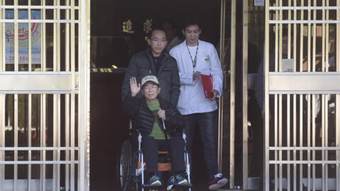 资料图片：2015年1月5日，因涉及多起贪污、洗钱案而被判入狱20年的台湾前总统陈水扁因健康问题获准保外就医，在儿子陪伴下走出监狱，向支持者招手致意。