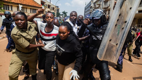 Members of the Uganda Police arrest protesters marching to parliament during a planned anti-corruption demonstration in Kampala on 23 July 2024.