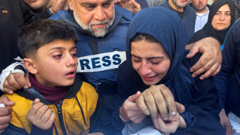 Al Jazeera journalist Wael Al-Dahdouh hugs his daughter and son as they attend the funeral of his son, Palestinian journalist Hamza Al-Dahdouh, after Hamza was killed in an Israeli strike, in Rafah in the southern Gaza Strip, 7 January, 2024. 