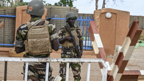 Nigerien soldiers stand guard outside the Niger and French airbases in Niamey as supporters of Niger's National Council for the Safeguard of the Homeland (CNSP) gather on 27 August 2023.