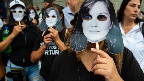 Activistas sostienen caretas que representan a la activista de derechos humanos y abogada Rocío San Miguel durante una manifestación frente a la embajada de España para exigir su liberación, en Caracas, el 20 de febrero de 2024.