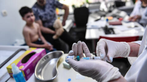 A doctor prepares a measles vaccine during a consultation in Bucharest, Romania.