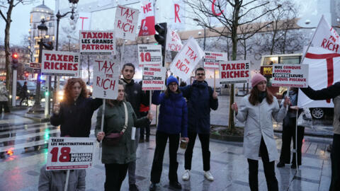 Ativistas da organização francesa Attac, favorável a mais impostos sobre os ultrarricos, se manifestam em frente ao futuro hotel Vuitton, na avenida Champs-Elysées, em Paris, em 24 de fevereiro de 2024.