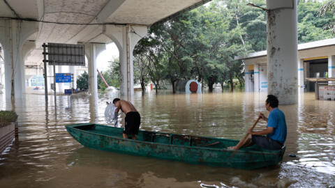 Des personnes traversent une route inondée avec un bateau à la suite de fortes pluies à Liuzhou, dans la région autonome de Guangxi Zhuang, en Chine, le 19 juin 2024.
