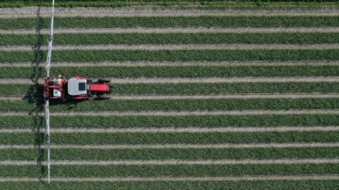 An aerial picture shows a tractor in a field in Plomeur, western France on March 22, 2021. 