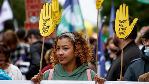 A protester in Paris on 15 June, 2024, holds a sign reading “hands off my buddy”, a slogan launched by France's SOS-Racisme movement in the mid-80s that has resurfaced during protests against the rise of the far right.