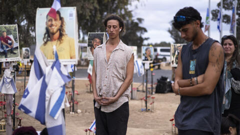 Un hombre medita mientras familiares y simpatizantes de los israelíes muertos en el atentado de Hamás del 7 de octubre asisten a una ceremonia en el monumento conmemorativo de Nova, cerca del kibutz Reim, en el sur de Israel, en el primer aniversario de los atentados, el 7 de octubre de 2024.