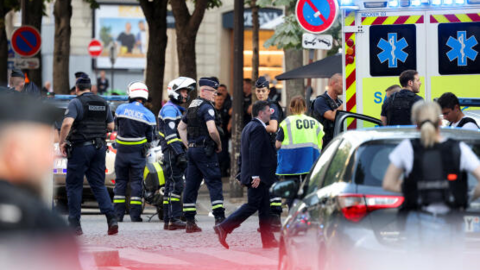 Des policiers se tiennent à côté d’une ambulance après qu’un officier de police a été blessé lors d’une attaque près de l’avenue des Champs-Elysées, à Paris, le 18 juillet 2024