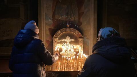 Pessoas colocam velas em altar da Catedral Ortodoxa São Miguel de Kiev. 