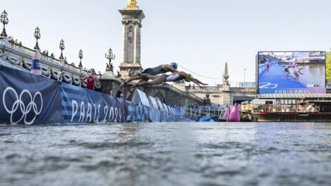 Athletes jump into the Seine in swimming race of the mixed relay triathlon at the 2024 Olympic Games in Paris, 5 August 2024. Authorities said the River's water quality was high enough Wednesday for athletes to swim the course of Thursday and Friday's marathon swim events after a similar trial was cancelled on Tuesday due to bacteria.