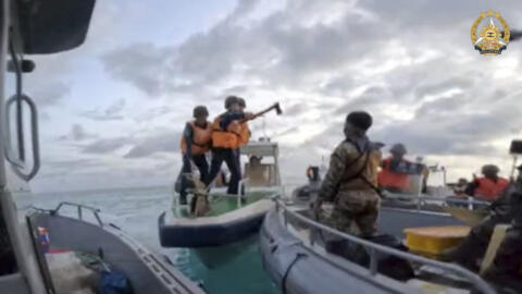 Une capture d'écran de la vidéo montrant un garde-côte brandir une hache face à des marins philippins le 17 juin 2024 à proximité de l'atoll de Second Thomas en mer de Chine méridionale. 视频截图显示，2024 年 6 月 17 日，一艘海岸警卫队快艇在仁爱礁附近向菲律宾水手挥舞斧头