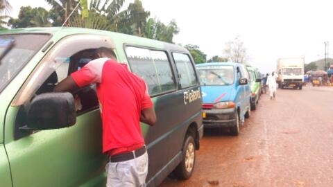 À l'arrêt de bus de PK12, au nord de Bangui, les bus s'alignent au bord de la route, attendant les passagers.