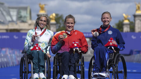 Catherine Debrunner, da Suíça, ao centro, Madison de Rozario, da Austrália, à esquerda, e Susannah Scaroni, dos EUA, posam com suas medalhas após a maratona feminina T54 nos Jogos Paralímpicos de Paris, neste domingo