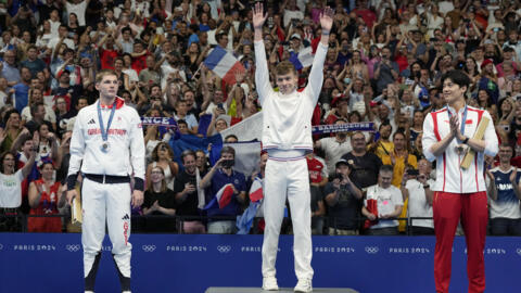 Kình ngư Léon Marchand (giữa) trên bục nhận tấm huy chương vàng thứ ở nôi dung bơi 200 mét hỗn hợp Olympic Paris 2024, ngày 02/08/2024, tại hồ bơi Arena Défense, Nanterre, ngoại ô Paris