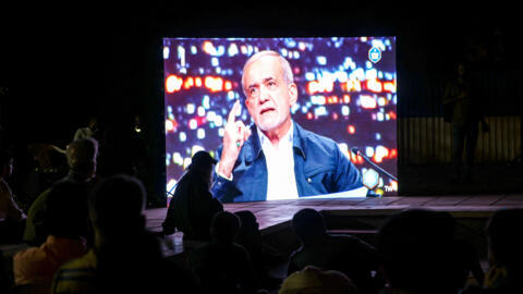 El candidato reformista Masoud Pezeshkian en la pantalla durante un debate de candidatos presidenciales el 17 de junio de 2024 en una plaza de Teherán.