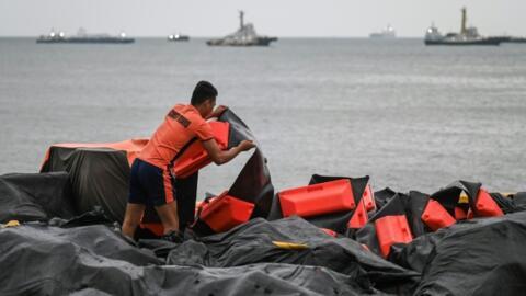 Un personal de la guardia costera arregla un boom de contención de derrames de petróleo que se utilizará en la bahía de Manila. Foto de ilustración.