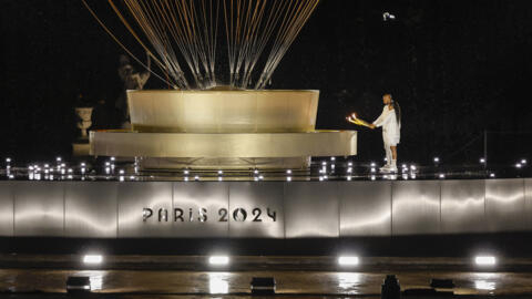 Les porteurs de la flamme olympique Marie-José Pérec et Teddy Rinner enflamment la vasque olympique lors de la cérémonie d'ouverture des JO-2024 à Paris le 26 juillet 2024.
