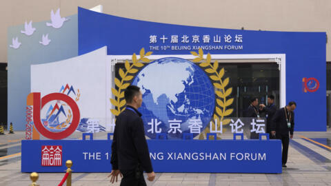 Workers walk past near the entrance to the venue ahead of the upcoming Xiangshan Forum in Beijing, Sunday, Oct. 29, 2023.