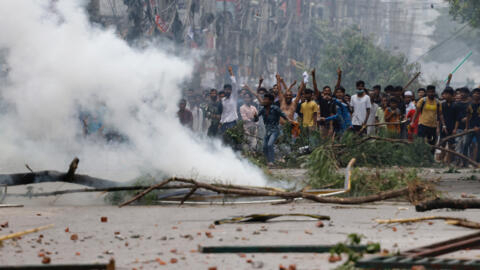 Manifestantes perante a polícia em Dacca, capital do Bangladesh, no passado dia 19 de Julho de 2024.