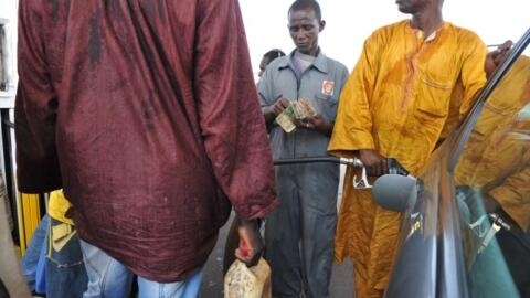 Un Guinéen fait le plein d'essence à Conakry. Après accord entre syndicats et gouvernements, les salaires des enseignants vont être revalorisés. Pour compenser, des coupes sont à prévoir, ce qui pourrait générer une hausse du prix à la pompe...