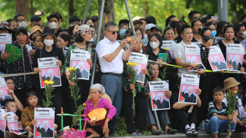 Mourners hold portraits of Vietnam's late general secretary of the Communist Party Nguyen Phu Trong as they line the streets during his funeral in Hanoi on July 26, 2024.LUONG THAI LINH / POOL / AFP