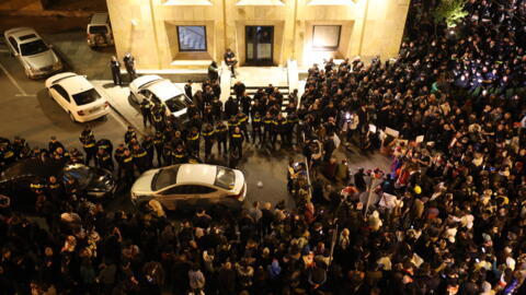 Manifestantes se reúnem do lado de fora do prédio do parlamento enquanto protestam contra um projeto de lei sobre "influência estrangeira" em Tbilisi no início de 18 de abril de 2024.