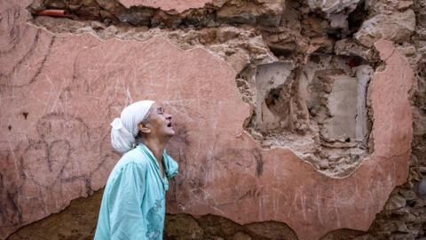 A woman reacts standing infront of her earthquake-damaged house in the old city in Marrakesh on September 9, 2023. A powerful earthquake that shook Morocco late September 8 killed more than 600 people, interior ministry figures showed, sending terrified residents fleeing their homes in the middle of the night. (Photo by FADEL SENNA / AFP)