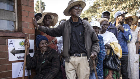 Voters queue outside a polling station during Zimbabwe's presidential and legislative elections in Harare, on 23 August 2023.