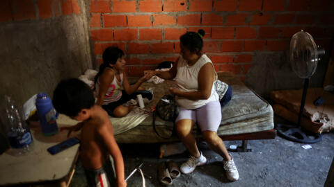 Uma mulher, 43 anos, dá ibuprofeno para sua filha, 11 anos, enquanto ela se recupera da dengue em sua casa em Villa Fiorito, um bairro de classe trabalhadora nos arredores de Buenos Aires, Argentina, em 27 de fevereiro de 2024.