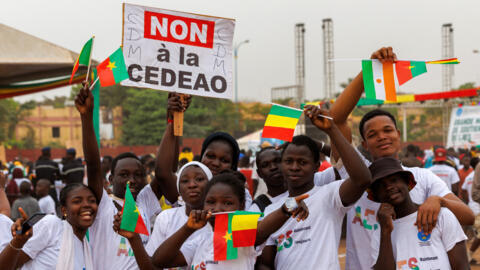 Supporter of the Alliance Of Sahel States (ASS) wave flags of Burkina Faso, Mali and Niger and a placard reading 'no to ECOWAS' during a rally to celebrate Mali, Burkina Faso and Niger leaving the Economic Community of West African States (ECOWAS) in Bamako on 1 February 2024