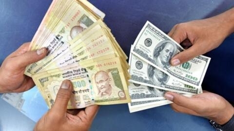 Indian customers at a foreign exchange outlet pose for a photo as they exchange Indian rupees (L) for US dollars in Bangalore on August 24, 2013. 