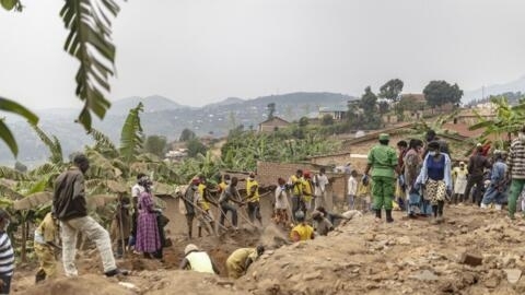 Moradores e voluntários escavam os restos humanos das vítimas do genocídio ruandês de 1994 escondidos sob as fundações de uma casa em Ngoma, Ruanda, em 23 de janeiro de 2024, onde mais de 82 corpos foram encontrados desde 21 de janeiro de 2024.