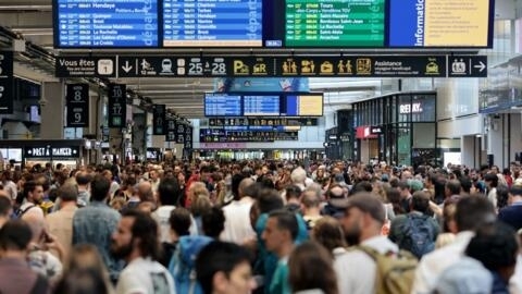 2024 年 7 月 26 日，法國高速鐵路網在 2024 年巴黎奧運會開幕式前幾個小時遭到惡意襲擊，交通系統中斷。圖為乘客們聚集在巴黎蒙帕納斯火車站的出發和到達指示牌周圍。