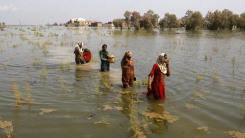 Mulheres paquistanesas percorrem atravessa regiões inundadas por enchentes para se refugiam no distrito de Shikarpur da província de Sindh, no Paquistão, em 2 de setembro de 2022. Espera-se que um novo e importante relatório das Nações Unidas, divulgado na segunda-feira, 20 de março de 2023, sirva para lembrar que o tempo está se esgotando se a humanidade quiser evitar passar por um perigoso limiar de aquecimento global.