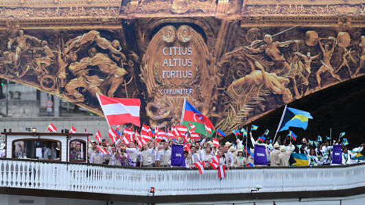 L'équipe d'Autriche, l'équipe d'Azerbaïdjan et l'équipe des Bahamas sous le pont d'Austerlitz sur la Seine pendant la cérémonie d'ouverture.