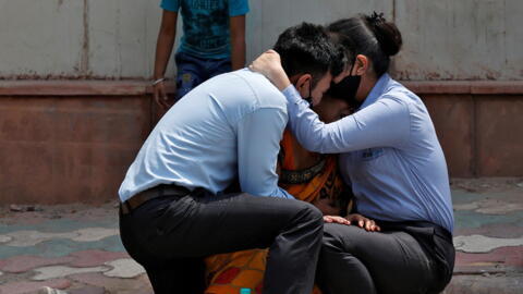 A woman is consoled by her children after her husband died from complications related to the coronavirus disease (COVID-19) outside a mortuary of a COVID-19 hospital in New Delhi, India, April 15, 2021.