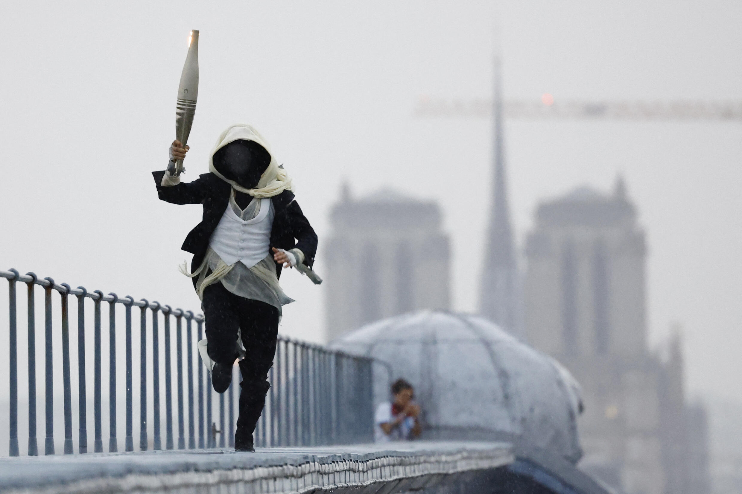 Un misterioso personaje enmascarado, inspirado del juego video Assassin's Creed, recorre la ciudad con la llama olímpica. Será quien encienda el pebetero al final de la ceremonia, cuando conoceremos su identidad.