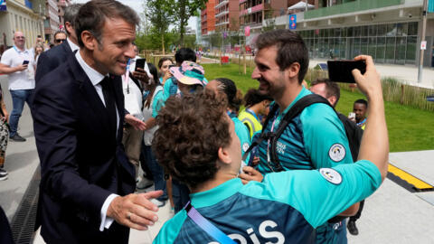 Rais wa Ufaransa Emmanuel Macron akipiga picha ya selfie na watu waliojitolea alipotembelea kijiji cha Olimpiki kwa ajili ya Michezo ya Olimpiki ya Majira ya Joto ya 2024, huko Paris, Ufaransa, Julai 22, 2024.