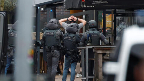 Ofițerii de poliție olandezi rețin o persoană lângă Cafe Petticoat, unde mai multe persoane sunt ținute ostatice în Ede, Țările de Jos, 30 martie 2024. REUTERS/Piroschka Van De Wouw