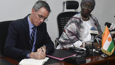 Nicolas Maes (L), CEO of French nuclear firm Orano, signs an agreement on the exploitation of uranium with the Nigerien Mining Minister Hadiza Ousseini in Niamey on May 4, 2023. 