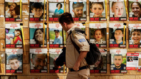 2024年2月12日，一名以色列士兵走过人质海报，海报上的路易斯-哈雷（Louis Hare）是以色列国防军在拉法行动中救出的以色列人质。