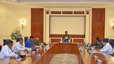 In this image provided by The Myanmar Military True News Information Team, Myanmar's military leader Senior Gen. Min Aung Hlaing, center, speaks during meeting with members of the National Defense and