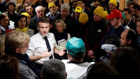 2024年2月24日，法国巴黎，第60届国际农业博览会开幕当天，法国总统马克龙在凡尔赛门展览中心与黄帽子农民示威者交谈。