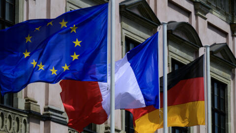 Les drapeaux de l'Union européenne, de la France et de l'Allemagne flottent devant le Musée historique allemand de Berlin, le 24 mai 2024, avant une visite d'État du président français Emmanuel Macron.