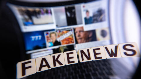 This illustration photograph shows letters reading "fake news" seen through a magnifying glass, against a laptop screen displaying other illustration images of various alleged fake news, disinformation campaigns or conspiracy theories, in Mulhouse, eastern France, on December 1, 2023 . (Photo by SEBASTIEN BOZON / AFP)