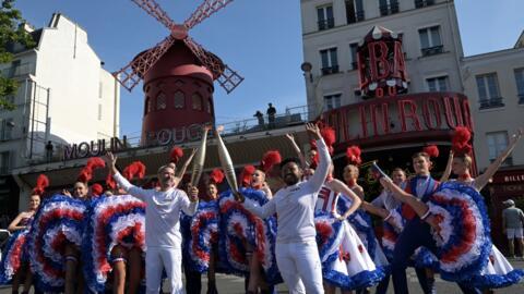 La llama olímpica en su paso por el Moulin Rouge de París, el 15 de julio de 2024.