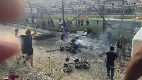 Residents rush to help injured children moments after a rocket attack hit a soccer field in the Druze town of Majdal Shams in the Israeli-controlled Golan Heights, Saturday, 27 July, 2024.