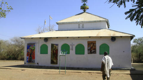 Un sudanés camina por el patio de una iglesia en el antiguo campo de refugiados de Um Gulja, en el estado oriental sudanés de Gedaref, el 15 de diciembre de 2023. Muchos refugiados y solicitantes de asilo que huyen de la actual guerra en Jartum y otras zonas de Sudán han buscado refugio en Um Gulja, un campo de refugiados que se cerró hace unos 20 años, pero que con la última guerra que estalló en la primavera de 2023 empezó a recibir de nuevo a desplazados. (Foto de Ebrahim Hamid / AFP)