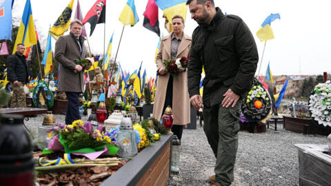 2024 年 2 月 23 日星期五，乌克兰利沃夫，乌克兰总统沃洛德梅尔-泽连斯基（Volodymyr Zelenskyy）、丹麦首相梅特-弗雷德里克森（Mette Frederiksen）和她的丈夫博-滕贝格（Bo Tengberg）（左）在利恰基夫公墓（Lychakiv Cemetery）的火星之地（Field of Mars）举行的悼念仪式上敬献花圈。(Mads Claus Rasmussen/Ritzau Scanpix via AP）。